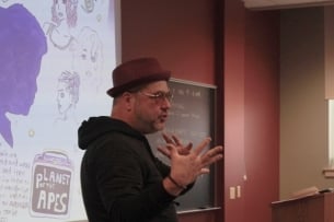 A Millersville University professor speaks to students, gesturing with his hands.