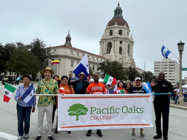 Pacific Oaks faculty, staff and students hold a banner during the Latino Heritage Parade and Festival in Pasadena. 