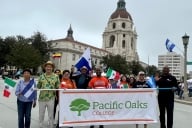 Pacific Oaks faculty, staff and students hold a banner during the Latino Heritage Parade and Festival in Pasadena. 