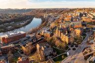 Aerial panoramic drone shot of the downtown campus of WVU in Morgantown, West Virginia, showing the river in the distance